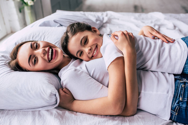 Die attraktive Tochter und eine Mutter liegen auf dem Bett - Foto, Bild