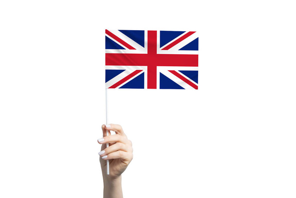 Beautiful female hand holding United Kingdom flag, isolated on white background. - Fotografie, Obrázek