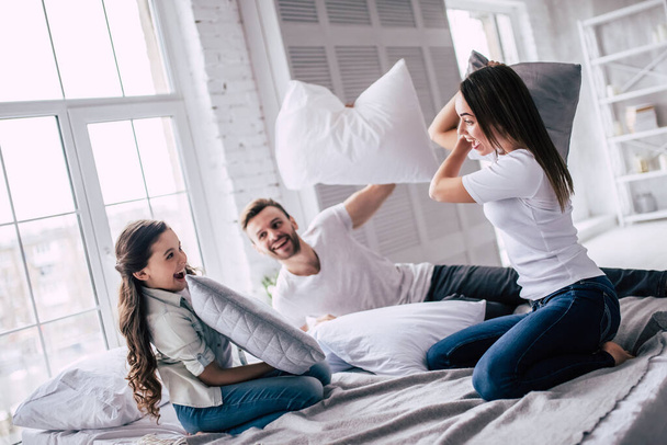 The happy family pillow fighting on the bed - Photo, Image