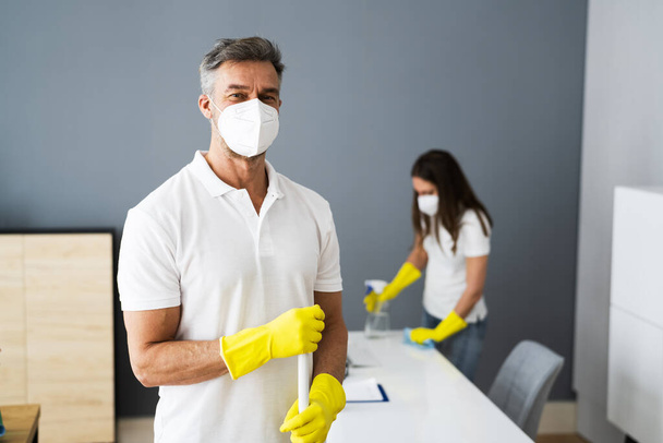 Cleaning Service Janitor Near Desk In Covid Face Mask - Foto, Imagen