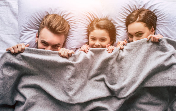 A família feliz deitado sob o cobertor - Foto, Imagem