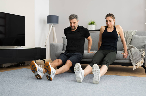 Couple Doing Home Fitness Workout And Exercise - Фото, изображение