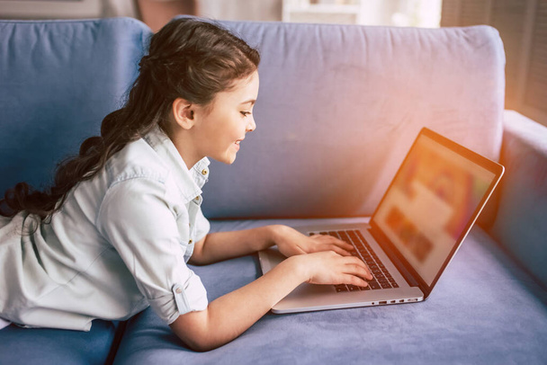Šťastná dívka ležící s laptopem na pohovce - Fotografie, Obrázek