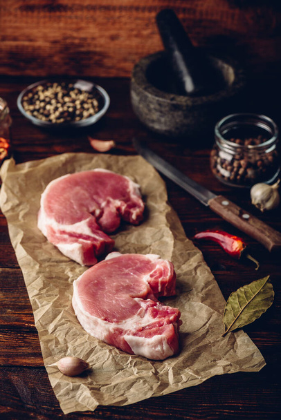 Pork loin steaks with ground spices on baking paper - Photo, image