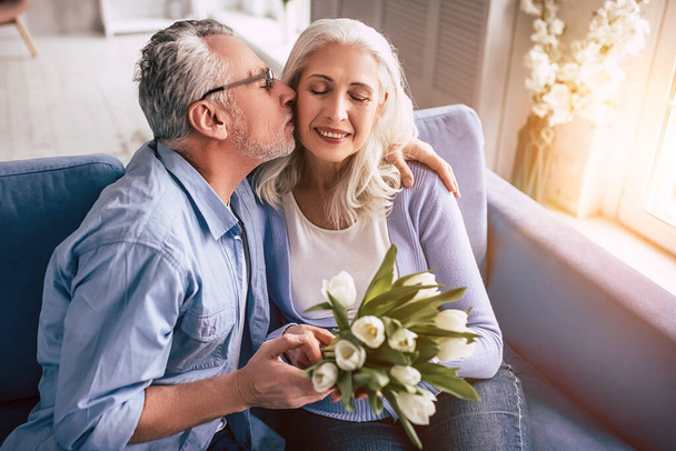 El anciano y una mujer con flores besándose - Foto, Imagen