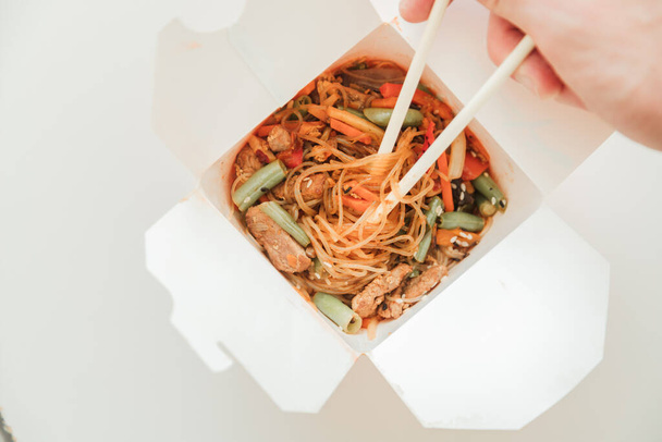 Wok noodles in takeaway box. Wheat noodles with peking duck and vegetables. Traditional chinese cuisine. - Photo, Image