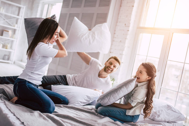 Onnellinen perhe tyyny taistelee sängyllä - Valokuva, kuva
