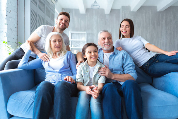 Счастливая семья сидит на диване - Фото, изображение