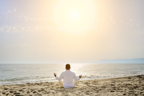 έννοια του υγιεινού τρόπου ζωής - άνθρωπος που κάνει γιόγκα, διαλογισμό ασκήσεις στην παραλία - Φωτογραφία, εικόνα