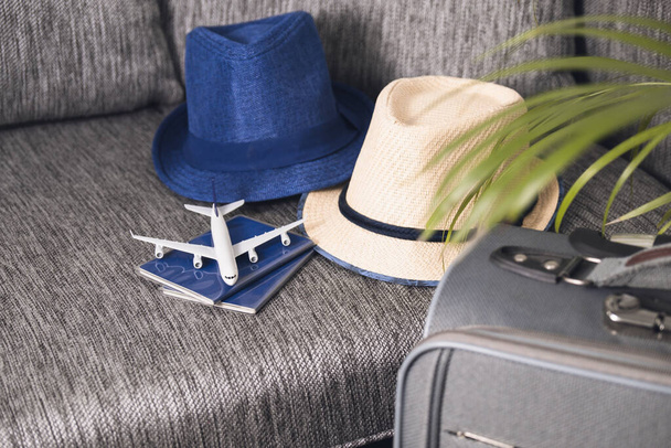Lifestyle and traveling concept after quarantine Passports, hat and model airplane on gray suitcase Prepairing Air travel - Foto, Bild