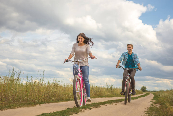 Щаслива пара їде на велосипеді на відкритому повітрі
 - Фото, зображення