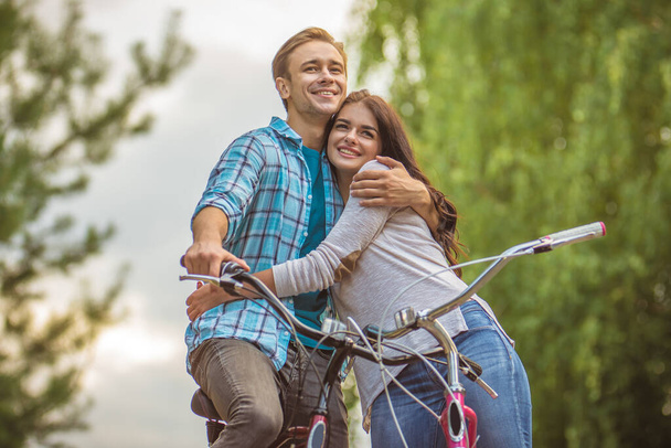 The man and woman with bikes hug outdoor - Foto, imagen