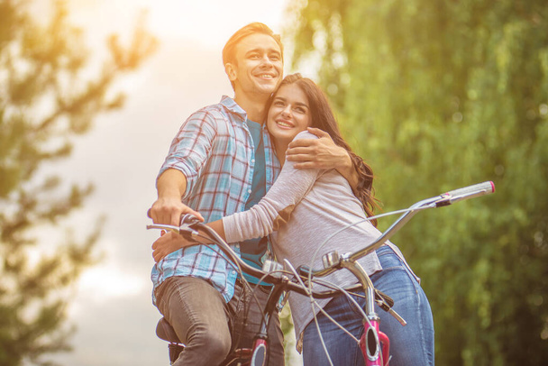 幸せな男抱擁A女性とともに自転車屋外 - 写真・画像