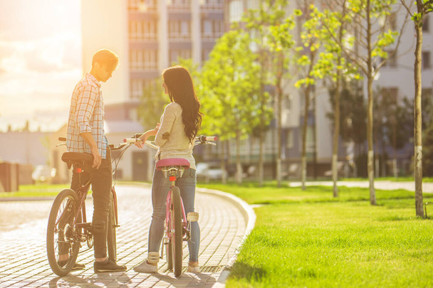 L'uomo e la donna in piedi con le biciclette vicino al moderno edificio - Foto, immagini