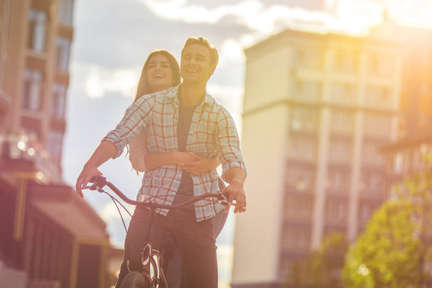 Šťastný muž a žena na kole v blízkosti moderní budovy - Fotografie, Obrázek