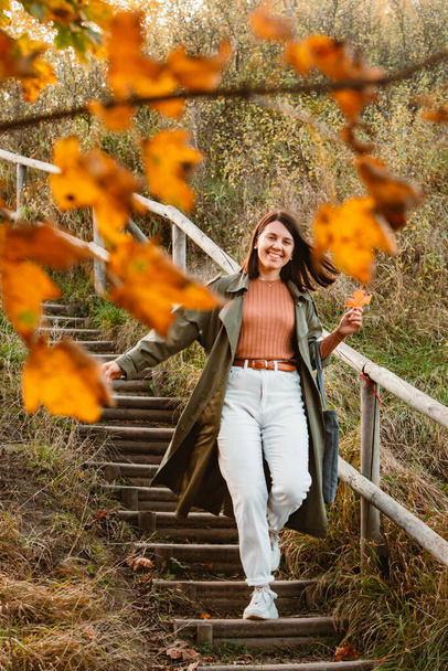 young adult smiling woman walking outdoors enjoying autumn weather. outfit - Photo, Image