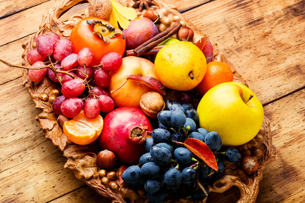Assortment of fruits,grapes and nuts.Autumn fruits.Autumn seasonal harvest - Foto, afbeelding