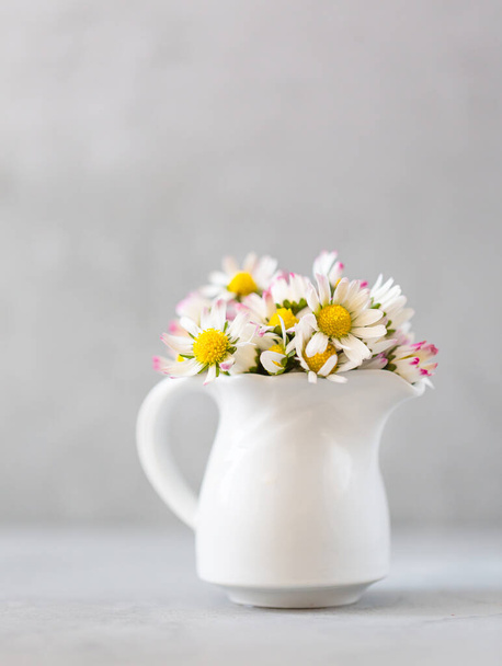 Daisy flowers in a vase on gray background with copy space. minimalist style. Spring holidays concept. Vertical Banner. Soft focus - Zdjęcie, obraz
