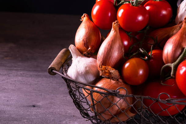Mutfağı süslemek için soğan sarımsaklı domatesli eski bir sepet. - Fotoğraf, Görsel