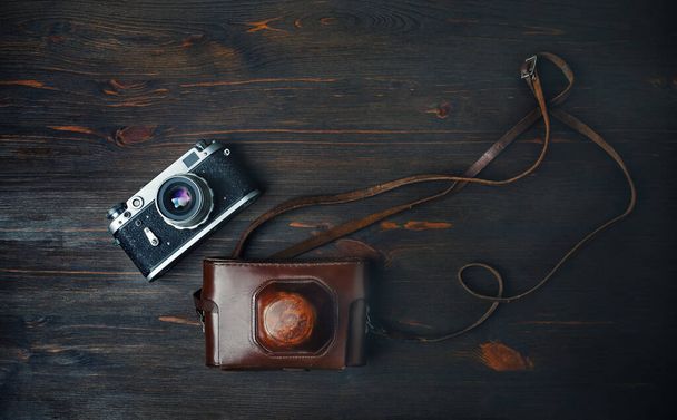 Old retro camera on vintage wooden background. Flat lay. - Photo, Image