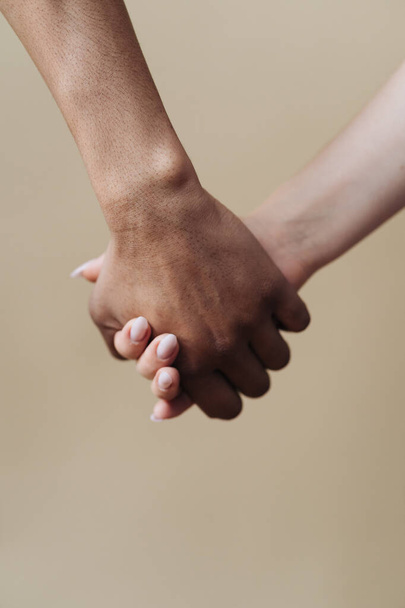 Fiatal, sokszínű pár fogja egymás kezét, beleegyeznek, hogy életre keltik a tervet. - Fotó, kép