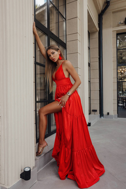 fashion photo of beautiful woman with blond hair in luxurious evening dress posing outdoor - Foto, afbeelding
