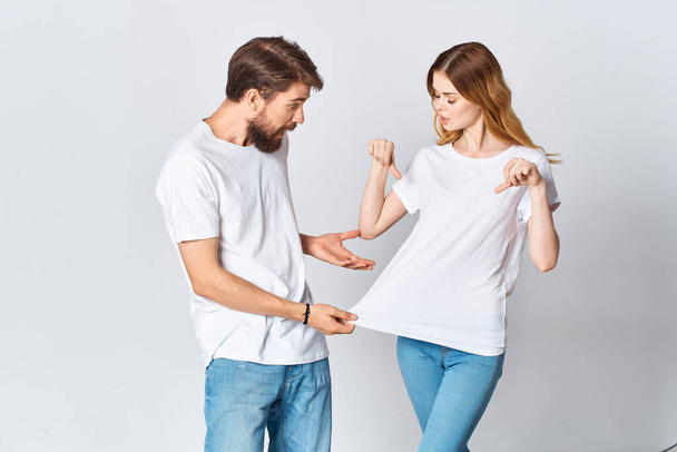 άνδρας και γυναίκα σε λευκό t-shirts κοινωνικοποίηση ποζάροντας σχέδιο μόδας - Φωτογραφία, εικόνα