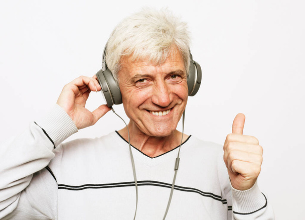 a portrait of smile old man with headphones show finger up - Фото, зображення