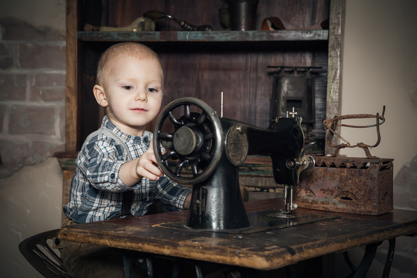 niño jugando con la máquina de coser
 - Foto, imagen