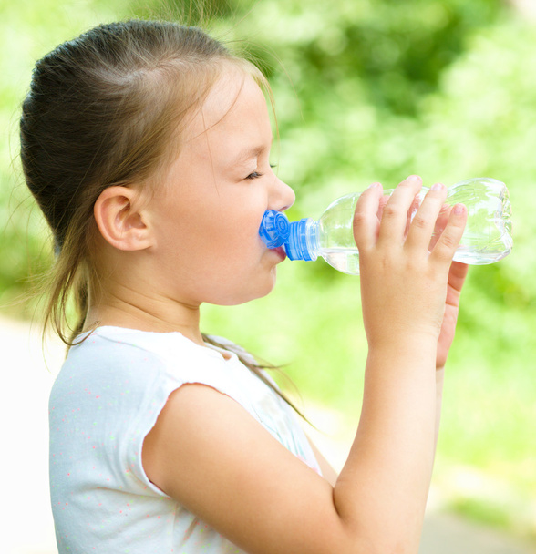 Милая девушка пьет воду из пластиковой бутылки
 - Фото, изображение