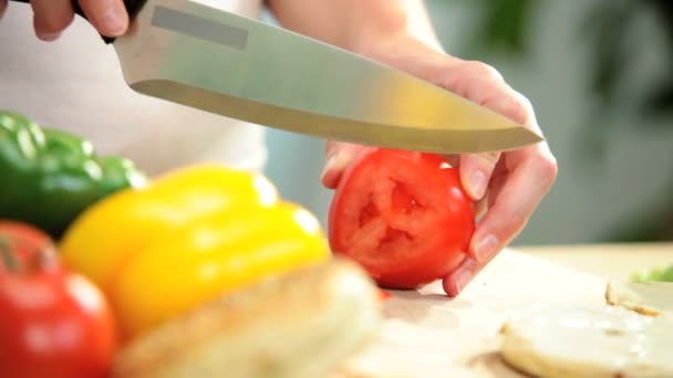 Manos femeninas rebanando tomates rojos
 - Metraje, vídeo