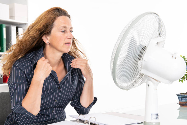 ділова жінка з вентилятором за своїм столом в літньому гарячому офісі
 - Фото, зображення