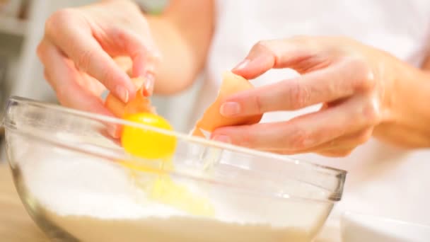 Weibliche Hände brechen Eier Schüssel Mehl aus nächster Nähe - Filmmaterial, Video