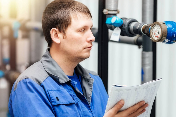 エンジニア、労働者はセンサーと圧力計の測定値を登録します。給水・暖房システムの制御 - 写真・画像