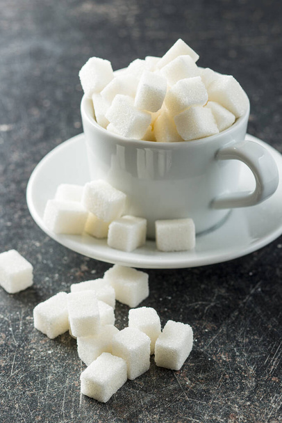 Sweet white sugar cubes in coffee mug. - Foto, Bild