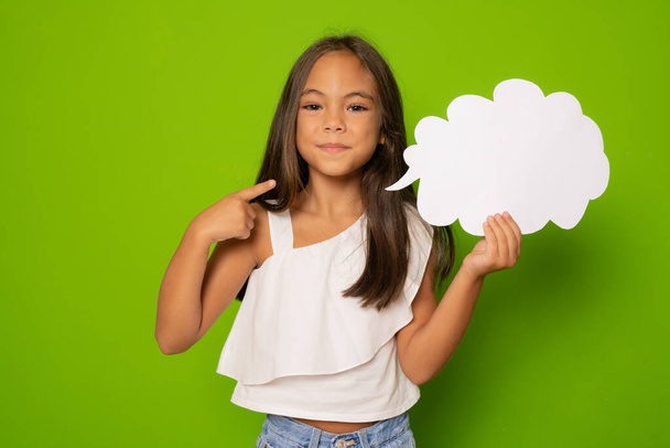 Retrato de linda chica alegre sosteniendo espacio de copia en la nube de papel aislado sobre fondo verde - Foto, imagen