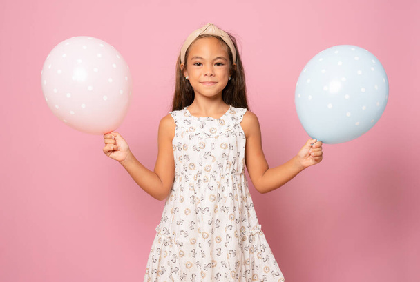 Beautiful little girl, with balls on pink background - Foto, Imagen