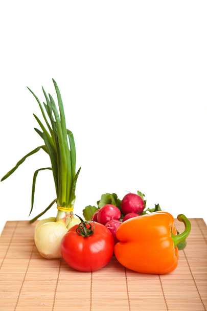 Different ripe vegetables compositions in studio laying on bamboo plate - Fotografie, Obrázek