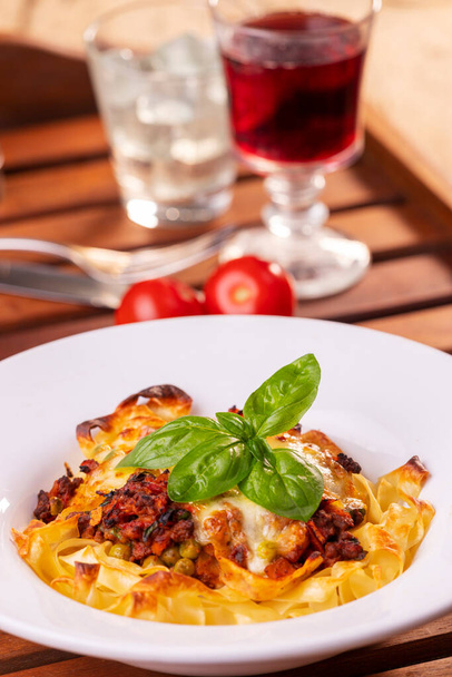tagliatelle baked with cheese on a plate - Foto, afbeelding