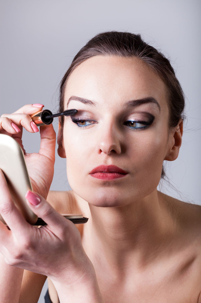 Woman painting eyelashes using mascara - Foto, Bild