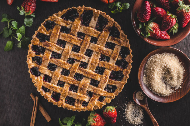 homemade strawberry pie with strawberries and mint on a dark wooden background. - Фото, зображення