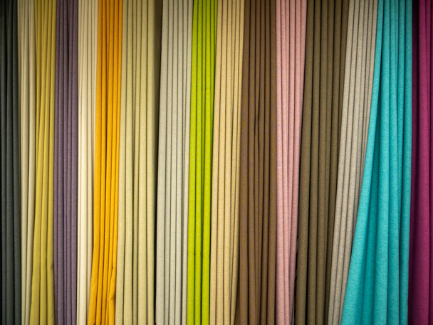 Negozio di tessuti e accessori per abiti da cucito. Campioni di tessuti naturali multicolori appesi alla vetrina. - Foto, immagini