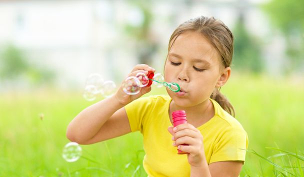 Little girl is blowing a soap bubbles - Zdjęcie, obraz