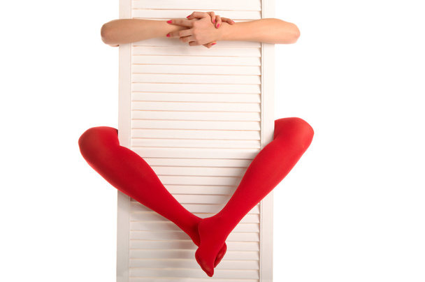 Female feet in red stockings, hands and door - Foto, imagen
