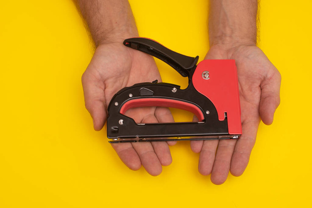 construction stapler gun in the hands. close-up - Photo, Image