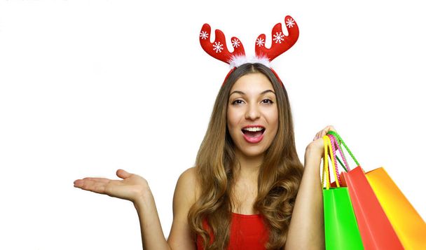 Pretty cheerful christmas woman with reindeer horns showing on her hand over white background. Copy space. - Fotoğraf, Görsel