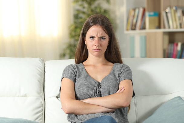 depressed woman sitting on sofa and looking at camera - Photo, image