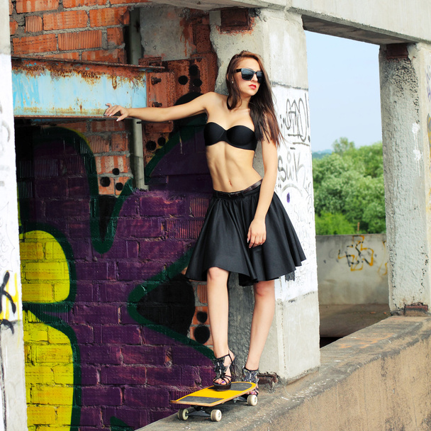κορίτσι στην κορυφή και φούστα με skateboard - Φωτογραφία, εικόνα