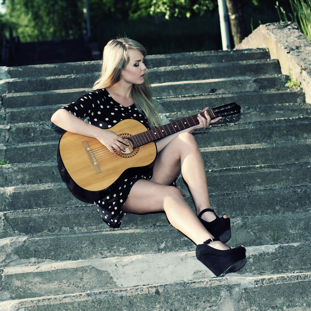 Chica sentada en escaleras con guitarra
 - Foto, Imagen