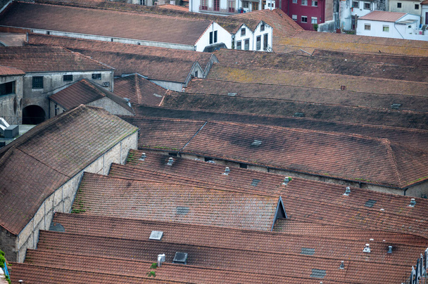 Vila Nova de Gaia, Πορτογαλία, 31 Οκτωβρίου 2020. Ερυθρές στέγες παλιών οινοποιείων ή σπηλαίων όπου αποθηκεύεται και παλαιώνεται λιμενικός οίνος για χρόνια - Φωτογραφία, εικόνα
